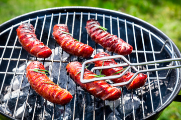 Spicy sausages with spices and rosemary on a grill