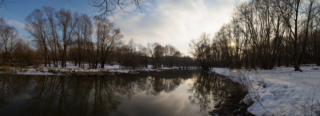 Панорама реки и деревьев в зимнем городском парке....