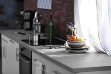 Naklejka na ściany i meble Modern kitchen table with electric stove beside the window