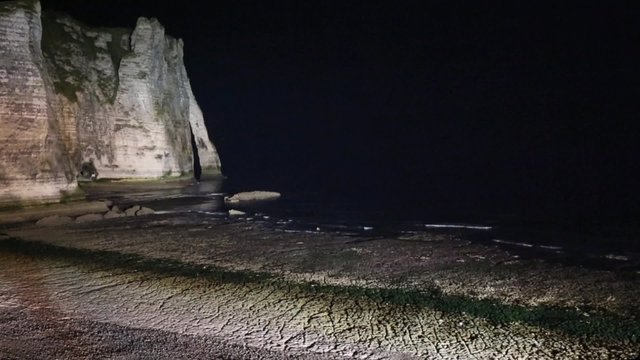 One of the three famous white cliffs known as the Falaise de Aval. Etretat, France. Night scene. There is surf noise. 
