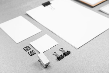 Office set with white sheets of paper and stationery on grey background