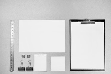Office set with white sheets of paper, notebook and stationery on grey background