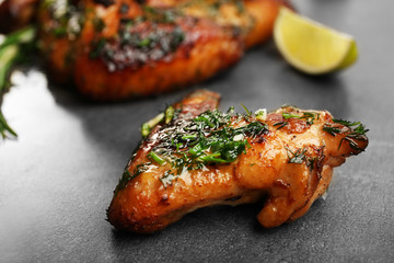 Baked chicken wings with spices and lime on grey background
