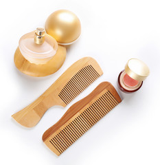 Wooden combs with cosmetics, isolated on white
