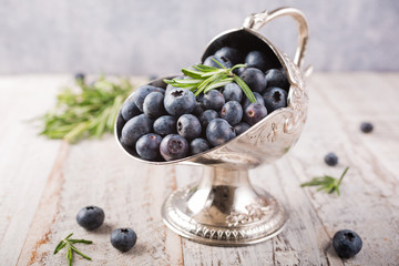 Fresh blueberries in vintage metal sugar bowl