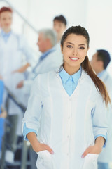 Portrait of doctor in front of colleagues indoors