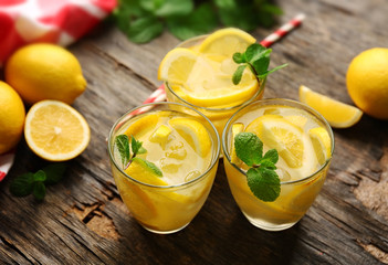 Composition lemonades with lemons and mint on wooden table background