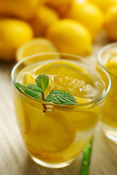 Lemonade with lemons and mint on white wooden table background, closeup