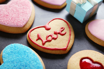 Assortment of love cookies with gift on blue wooden table background