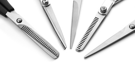 Five professional metal scissors laying in semicircle isolated on white background