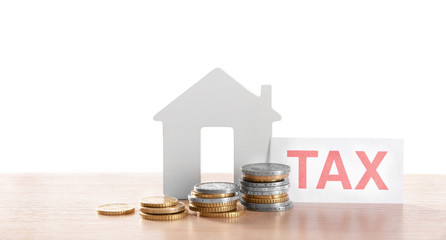 House figure, coins and tax sign, closeup