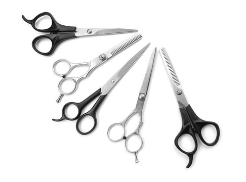Five professional scissors with black and metal handles in shut positions isolated on white background
