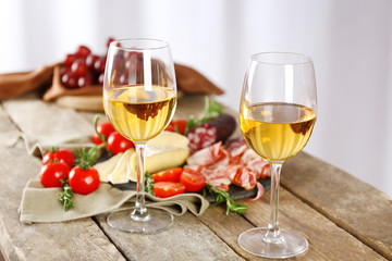 Two glasses of wine with food on blurred background