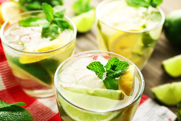 Three mojito drinks with lime, lemon and mint, closeup