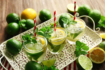Mojito drinks with lime, lemon and mint on patterned tray