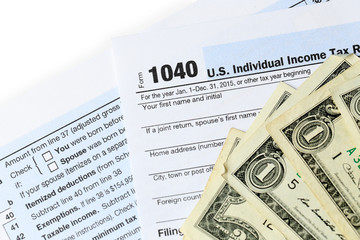 Obraz premium 1040 Individual Income Tax Return Form for 21015 year with one hundred dollar bills on white background, close up