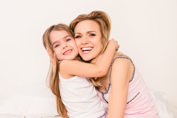 Fototapeta na wymiar Close up portrait of little girl smiling and huging her mom