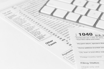 Naklejka na ściany i meble 1040 Individual Income Tax Return Form for 2015 year with a computer keyboard on the white desk, close up