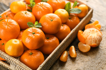 Full basket of fresh, delicious tangerines on the rustic table, close up