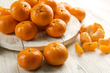 Delicious tangerines and mandarin with slices on the wooden table, close up