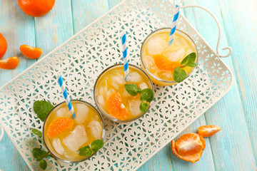 Fresh cocktails with ice, mint and tangerines on a white metal tray, top view