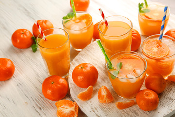 Tangerine cocktails with ice and mint on a white wooden board, close up