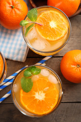 Tangerine cocktails with ice and mint  on a checkered napkin, top view