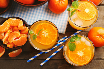 Tangerine cocktails with ice and mint  on a checkered napkin, top view