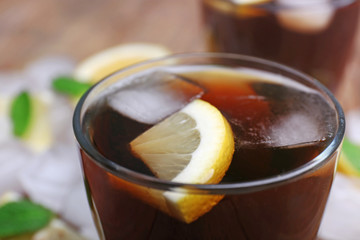 Glass of cola with cubes of ice and lemon, closeup