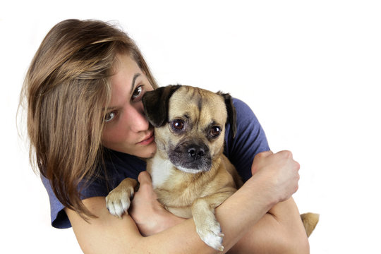 Jugendlicher umarmt kleinem Mopsmix