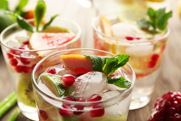 Refreshing cocktails with ice, mint, pomegranate seeds and slices of fruits