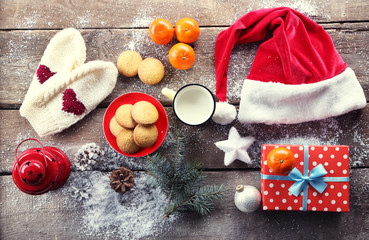 Christmas composition with a Santa hat, cookies and decorations on a wooden table