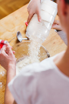Mother and daughter pouring flour into bowl