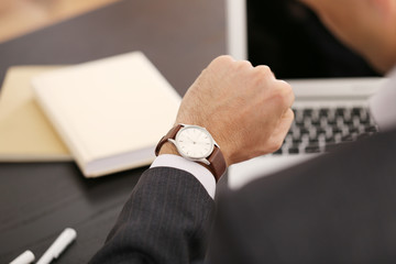 Businessman checking the time on his wrist watch, close up
