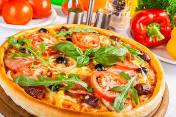 Pizza with tomato, salami and olives