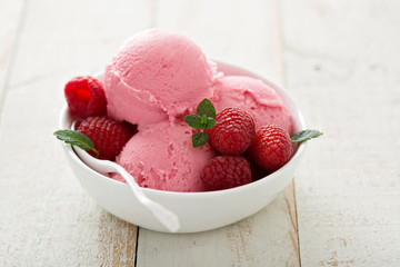 Raspberry ice cream in white bowl