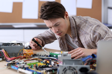 Young man working with screwdriver in service center