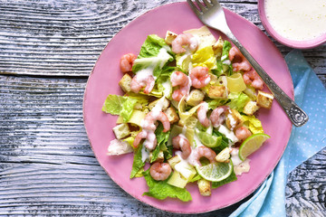 Caesar salad with shrimps and cheese.