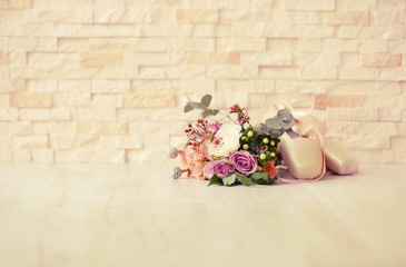 Bouquet of roses and ballet shoes on brick wall background