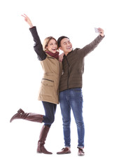 Young couple taking selfie in their winter clothes isolated on white