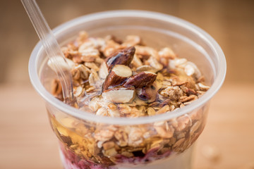 yogurt with granola,honey, almond and fresh berries on the bright wooden board
