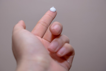 Beautiful young woman hands with cream