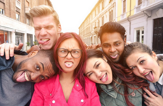 Multiracial best friends taking selfie outdoors in urban contest