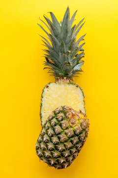 Natural and complete pineapple on a solid yellow background and flat