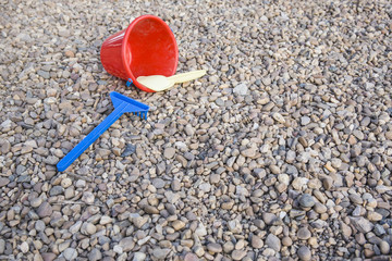 Fototapeta na wymiar Child sand toys over stony playground