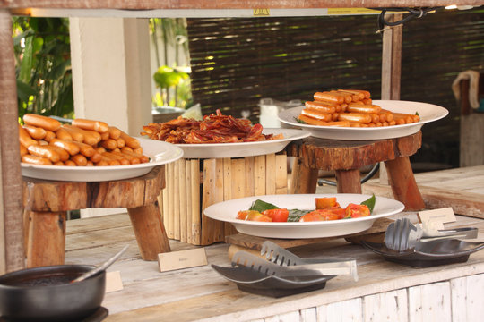 Breakfast bar buffet at restaurant. Sausage, bacon and baked tom
