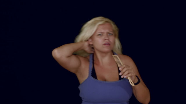 Funny blond woman dancing and singing with comb, studio isolated.