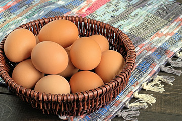  Eggs.  Chicken eggs in a wicker basket on a homespun rug.
