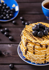 Wafers with chocolate sauce and blueberry on dark wooden background 