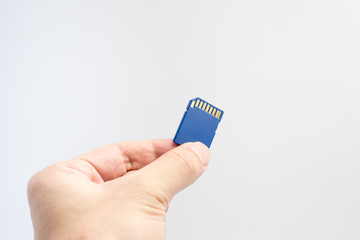 SD memory card with hand and finger hold isolate on white background.